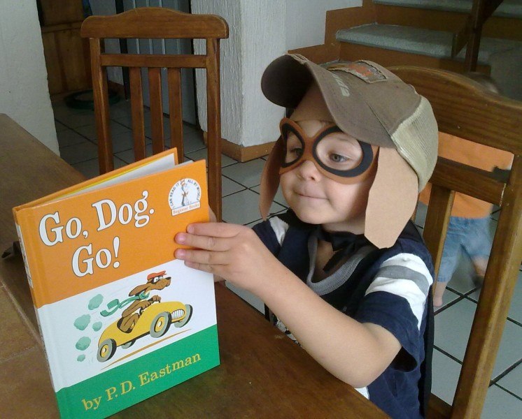 A Sonlight student reads while wearing a puppy dog hat